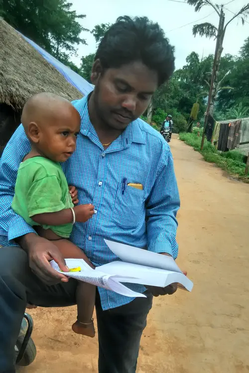 man holding a baby while reading