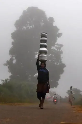 woman carrying tower of water pots on her head