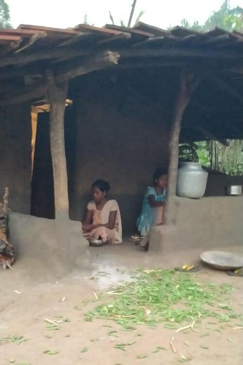 2 women sitting at the entrance of a house