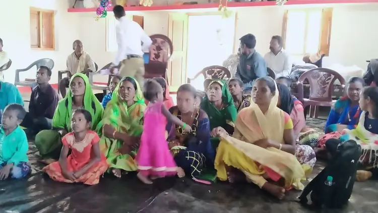 group of women and children sitting on the floor in a meeting
