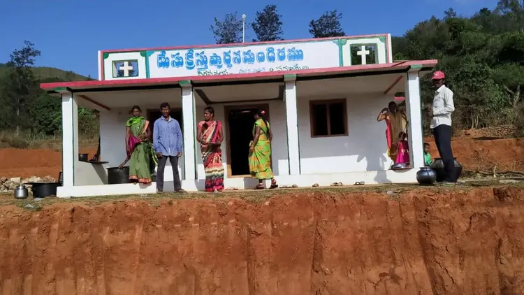 church building with a few people gathered outside